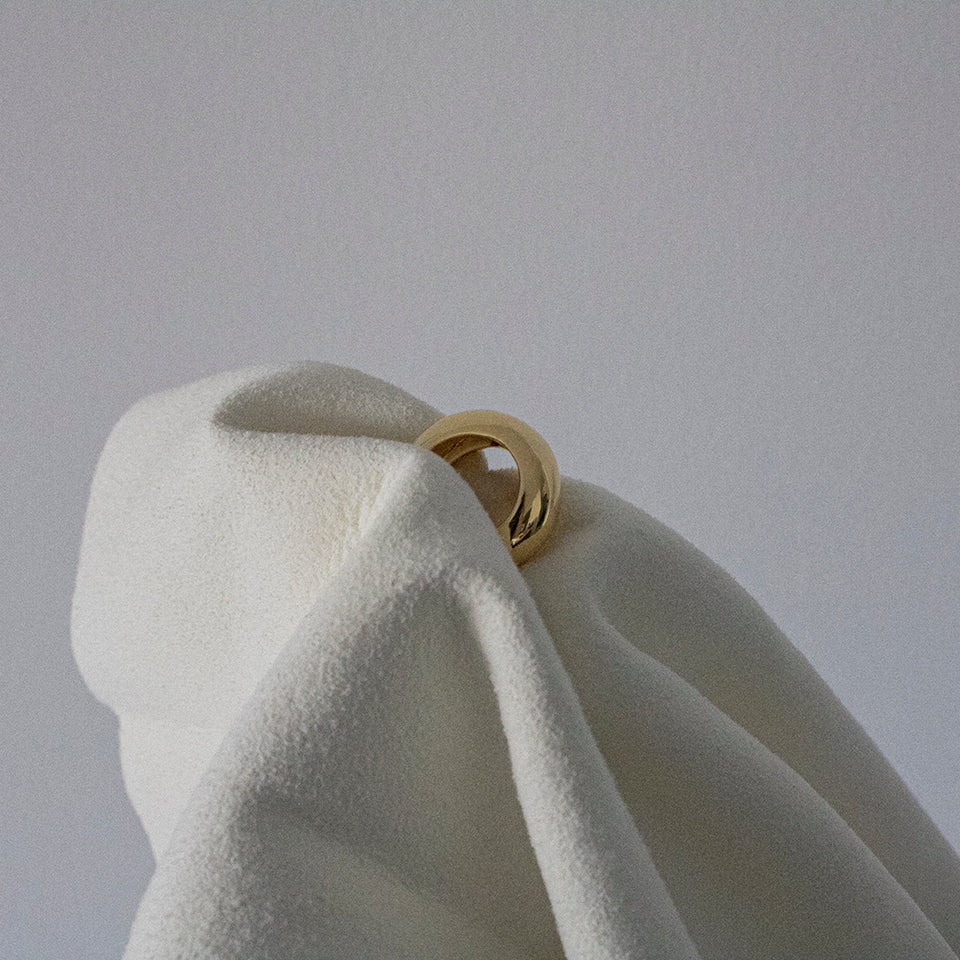 Polishing cloth holding gold hoop earring 